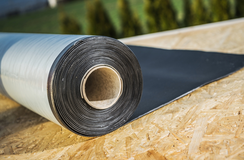 A roll of EPDM roofing material laid out on a flat roof, showcasing modern roofing materials for construction
